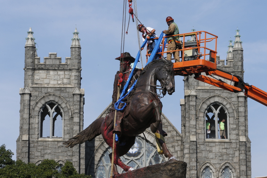 FILE - In this July 7, 2020, file photo, crews attach straps to the statue Confederate General J.E.B. Stuart on Monument Avenue in Richmond, Va. At least 160 Confederate symbols were taken down or moved from public spaces in 2020. That&#039;s according to a new count the Southern Poverty Law Center shared with The Associated Press.