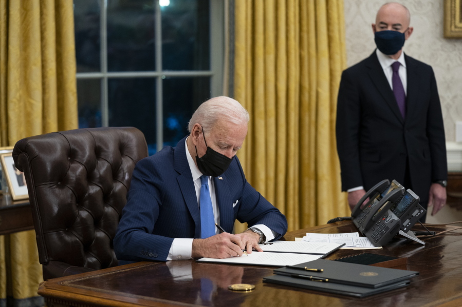 FILE - In this Tuesday, Feb. 2, 2021, file photo, Secretary of Homeland Security Alejandro Mayorkas looks on as President Joe Biden signs an executive order on immigration, in the Oval Office of the White House in Washington. Faith-based organizations involved in refugee resettlement are celebrating President Joe Biden&#039;Aos new executive order that intends to lift the number of refugees admitted to the U.S. to 125,000 &#039;Ai a massive increase compared to reduced numbers under former President Trump.