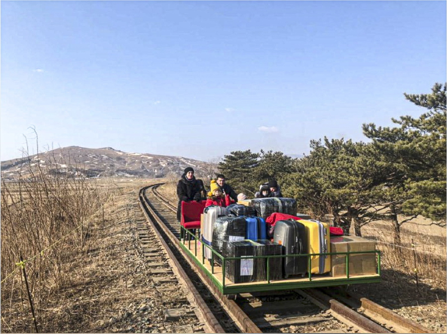In this image taken from a video released by Russian Foreign Ministry Press Service Thursday, Feb. 25, 2021, a group of Russian diplomats push hand-pushed rail trolley with their children and suitcases to the border with Russia. A group of Russian diplomats and their family members returned to Russia from North Korea on a hand-pushed rail trolley on Thursday because of COVID-19 restrictions in the country, Russia&#039;s Foreign Ministry said in a Facebook post.
