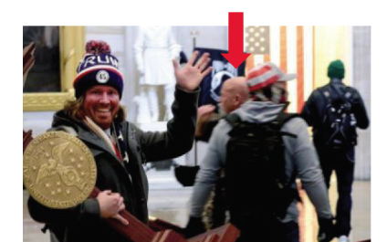 A photo included in federal charging documents shows Battle Ground resident Jeffrey Grace, 61, in the background of a photo of a man carrying U.S. House Speaker Nancy Pelosi's lectern during the Jan. 6 riot at the U.S. Capitol. Grace was arrested by federal authorities Thursday on suspicion of one count of unauthorized entering or remaining in any restricted building or grounds. (U.S.