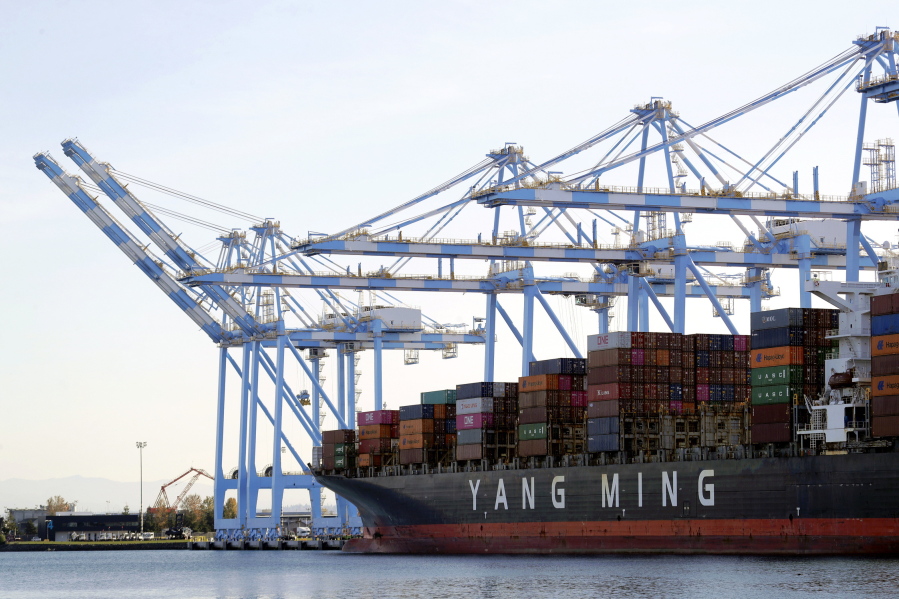 FILE - In this Nov. 4, 2019, file photo, cargo cranes are used to take containers off of a Yang Ming Marine Transport Corporation boat at the Port of Tacoma in Tacoma, Wash.  The Commerce Department said Thursday, Jan. 7, 2021, the U.S. trade deficit jumped to $68.1 billion in November as a surge in imports overwhelmed a smaller increase in exports. (AP Photo/Ted S.