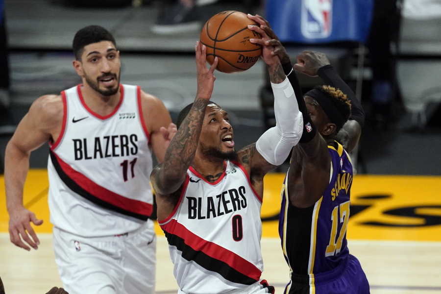 Los Angeles Lakers guard Dennis Schroder (17) blocks a shot by Portland Trail Blazers guard Damian Lillard (0) during the first half of an NBA basketball game Friday, Feb. 26, 2021, in Los Angeles. (AP Photo/Mark J.