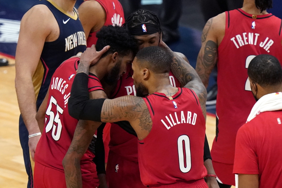 Portland Trail Blazers guard Damian Lillard (0) celebrates with forward Derrick Jones Jr. (55) and forward Robert Covington after the team&#039;s victory over the New Orleans Pelicans in an NBA basketball game in New Orleans, Wednesday, Feb. 17, 2021.