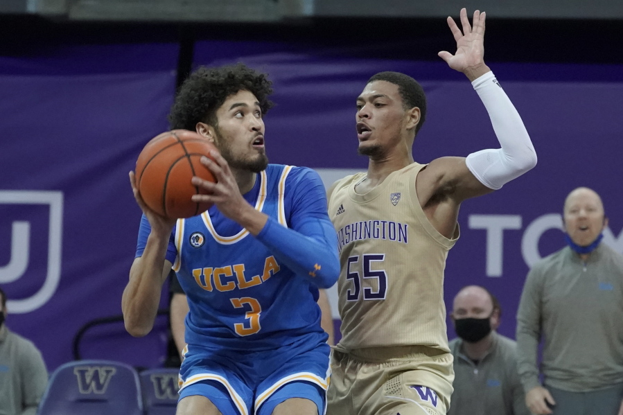 UCLA guard Johnny Juzang, left, looks to shoot around the defense of Washington guard Quade Green (55) during the second half of an NCAA college basketball game, Saturday, Feb. 13, 2021, in Seattle. (AP Photo/Ted S.