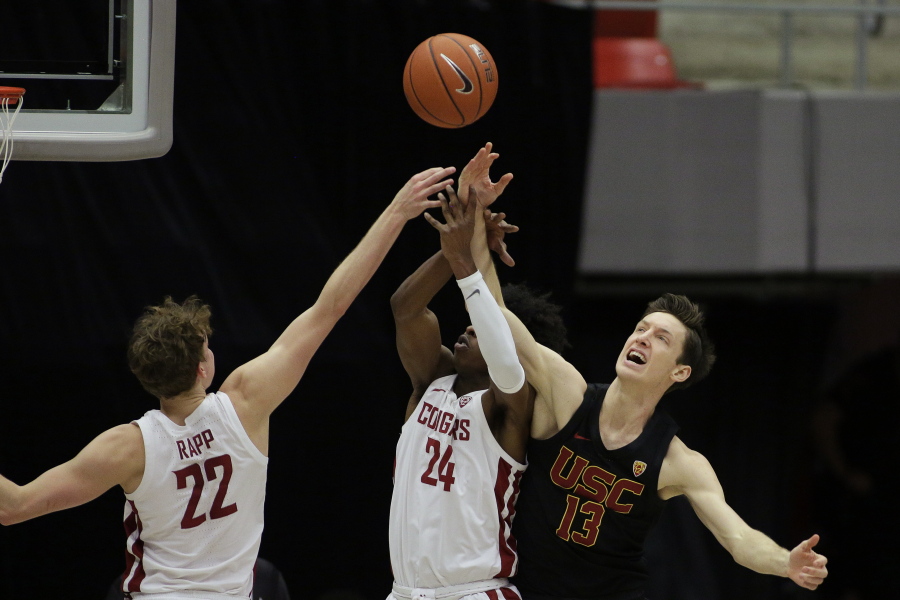 Washington State guards Ryan Rapp (22) and Noah Williams (24) and Southern California guard Drew Peterson (13) go after a rebound during the second half of an NCAA college basketball game in Pullman, Wash., Saturday, Feb. 13, 2021.