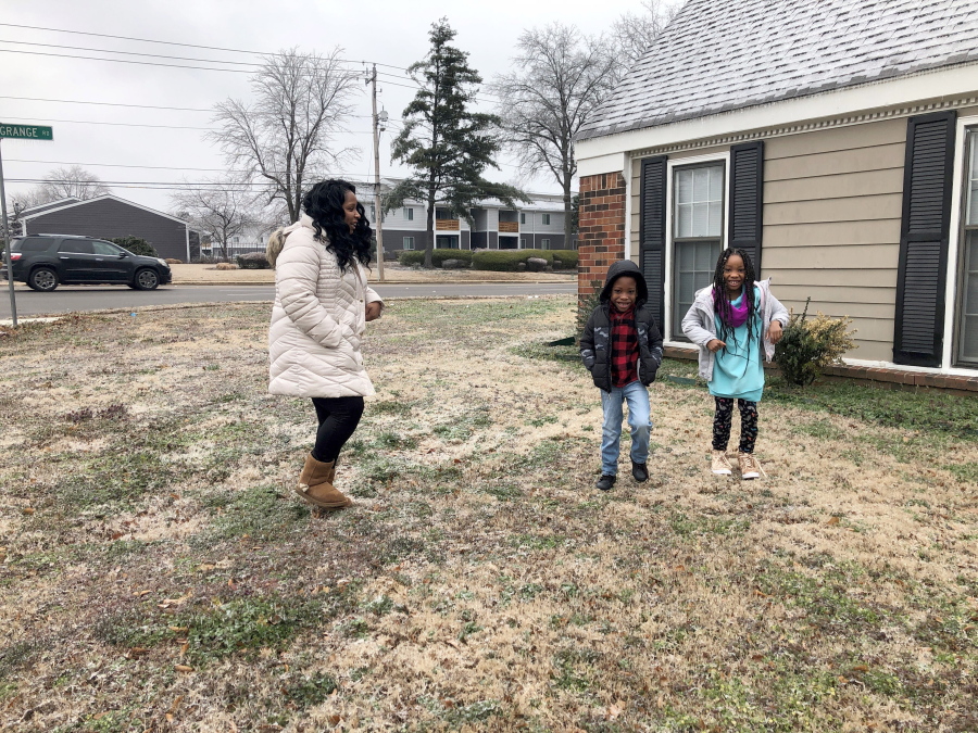 Leah Williamson, left, and her twin 7-year-old children Carpenter Adoo, center, and Sira Joy Adoo jump on the icy, frozen ground outside their home on Saturday, Feb. 13, 2021, in Memphis, Tenn. Carpenter&#039;s medical condition makes him particularly vulnerable to COVID-19, putting him in a population that states are wrestling with how to prioritize as vaccine supplies fall short of demand. Tennessee last month joined a handful of states in moving the families of medically frail children like Carpenter up the vaccine priority list.