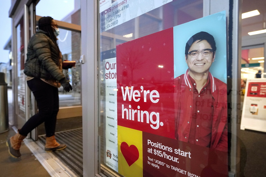 FILE - In this Feb. 9, 2021 file photo, a passer-by walks past an employment hiring sign while entering a Target store location, in Westwood, Mass.   The Federal Reserve says there&#039;s evidence that hiring has picked up in recent weeks, though the job market remains badly damaged by the pandemic. In its semi-annual monetary policy report released Friday, Feb. 19, the Fed says job data compiled by payroll processor ADP indicate that employment improved modestly through early February.