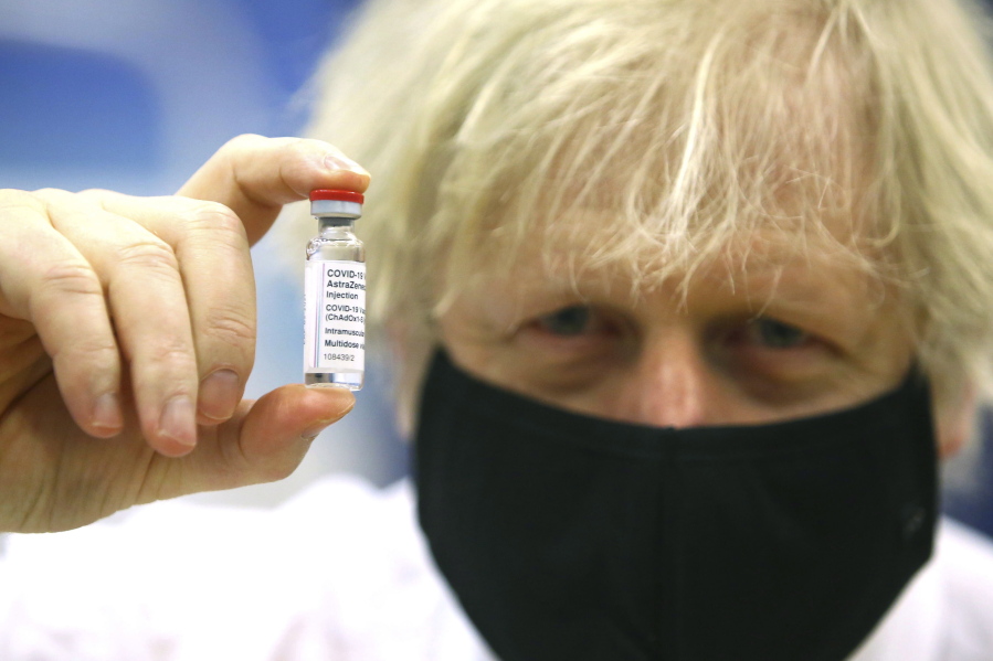 FILE - In this Wednesday, Feb. 17, 2021 file photo, Britain&#039;s Prime Minister Boris Johnson holds a vial of the Oxford/Astra Zeneca Covid-19 vaccine at a vaccination centre in Cwmbran, south Wales. The British government says it aims to give every adult in the country a first dose of coronavirus vaccine by July 31, a month earlier than its previous target. In addition, the goal is for everyone over 50 or with an underlying health condition to get a shot by April 15, rather than the previous target of May 1.