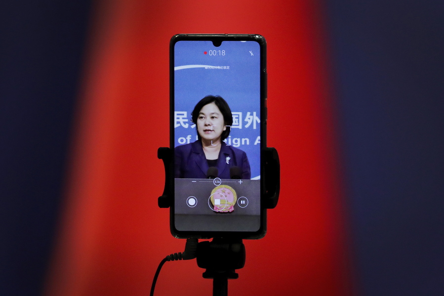 FILE - In this Sept. 1, 2020 file photo, a smartphone records Chinese Foreign Ministry spokeswoman Hua Chunying as she speaks during a daily briefing at the Ministry of Foreign Affairs in Beijing. &quot;I&#039;d like to stress that if the United States truly respects facts, it should open the biological lab at Fort Detrick, give more transparency to issues like its 200-plus overseas bio-labs, invite WHO experts to conduct origin-tracing in the United States,&quot; she said at a January 2021 MOFA press conference that went viral in China.