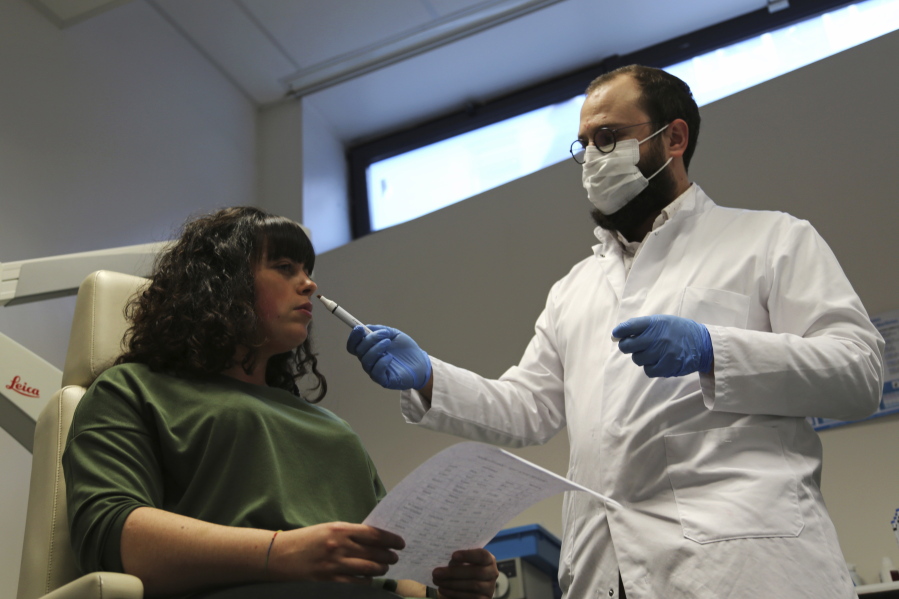 Dr. Clair Vandersteen, right, wafts a tube of odors under the nose of a patient, Gabriella Forgione, during tests in a hospital in Nice, southern France, Monday, Feb. 8, 2021, to help determine why she has been unable to smell or taste since she contracted COVID-19 in November 2020. A year into the coronavirus pandemic, doctors and researchers are still striving to better understand and treat the accompanying epidemic of COVID-19-related anosmia -- loss of smell -- draining much of the joy of life from an increasing number of sensorially frustrated longer-term sufferers like Forgione.