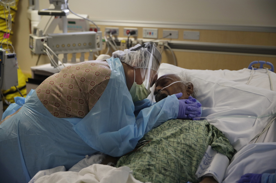 FILE - In this July 31, 2020, file photo, Romelia Navarro, 64, weeps while hugging her husband, Antonio, in his final moments in a COVID-19 unit at St. Jude Medical Center in Fullerton, Calif. The U.S. death toll from COVID-19 has almost topped 500,000 -- a number so staggering that a top health researchers says it is hard to imagine an American who hasn&#039;t lost a relative or doesn&#039;t know someone who died. (AP Photo/Jae C.