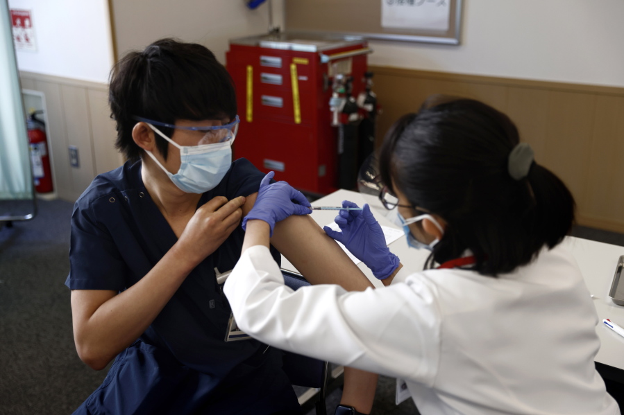 A medical worker receives a dose of COVID-19 vaccine at Tokyo Medical Center in Tokyo Wednesday, Feb. 17, 2021. Japan&#039;s first coronavirus shots were given to health workers Wednesday, beginning a vaccination campaign considered crucial to holding the already delayed Tokyo Olympics.
