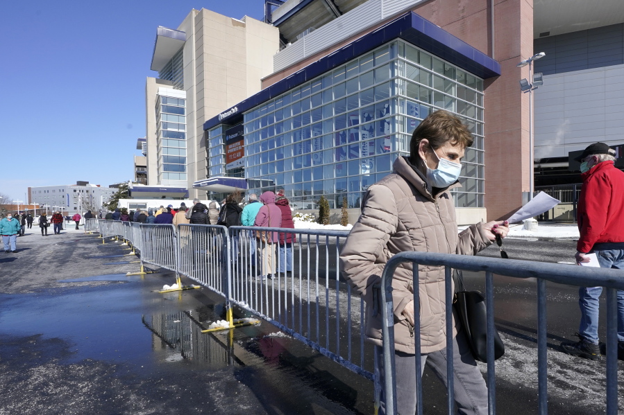 People enter a socially distanced line to get their COVID-19 vaccinations at Gillette Stadium, Monday, Feb. 8, 2021, in Foxborough, Mass.