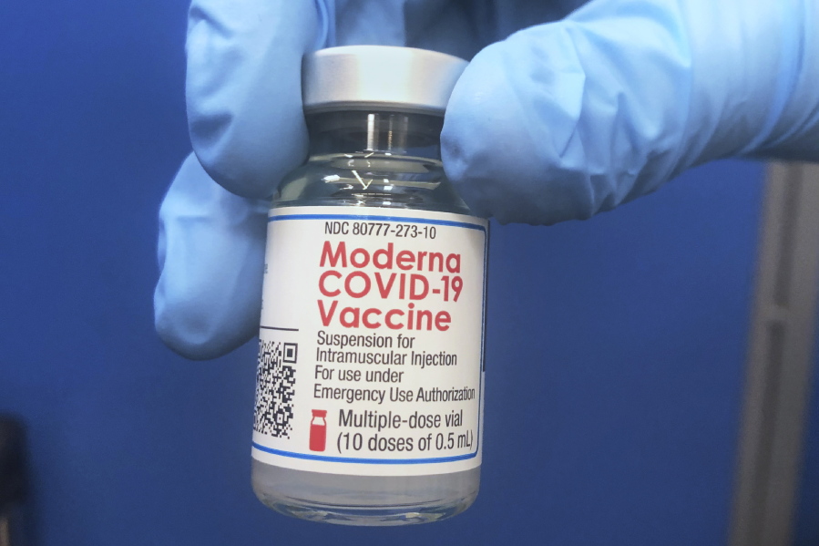 A vial of Moderna COVID-19 vaccine is held at a vaccination site Friday, Feb. 19, 2021, in Oklahoma City.