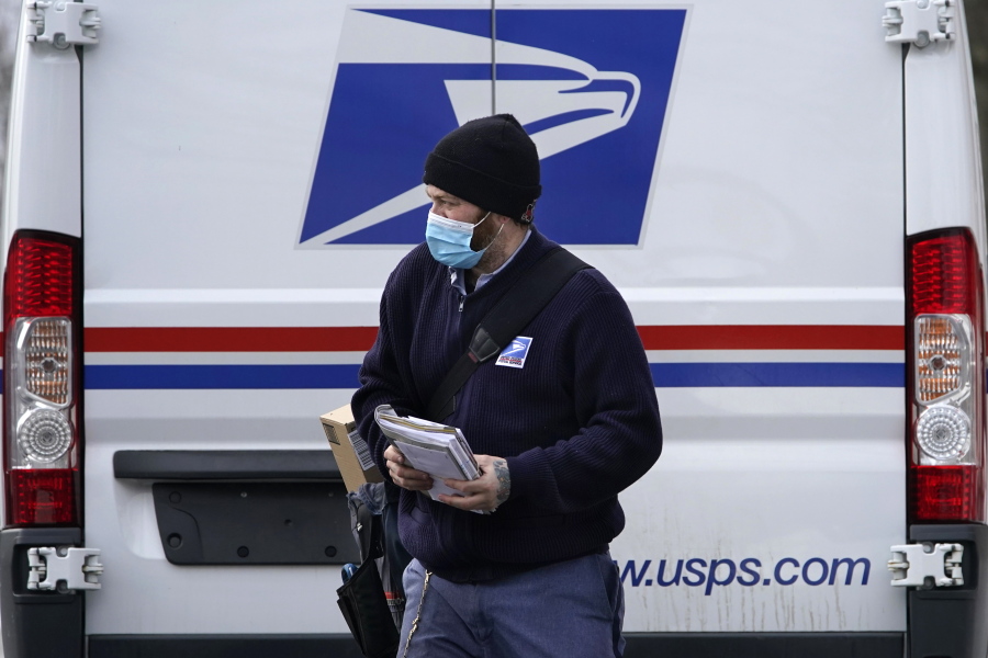 Postal carrier Josiah Morse heads out to deliver mail and packages, Wednesday, Feb. 3, 2021, in Portland, Maine. The U.S. Postal Service&#039;s stretch of challenges didn&#039;t end with the November general election and tens of millions of mail-in votes. The pandemic-depleted workforce fell further into a hole during the holiday rush, leading to long hours and a mountain of delayed mail. (AP Photo/Robert F.