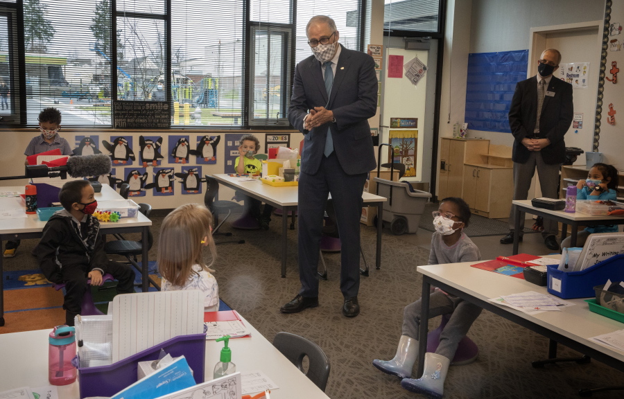 Washington Gov. Jay Inslee speaks with kindergartners in Chelsea Singh&#039;s class during a visit to Firgrove Elementary School in Puyallup, Wash., Thursday, Feb. 18, 2021. Students are back in school and all teachers and students are wearing masks. (Ellen M.