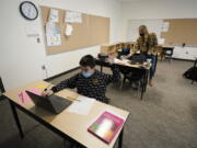 Jonny Velasquez, 9, wears a mask as he raises his hand with a question while working in a fourth-grade classroom, Tuesday, Feb. 2, 2021, at Elk Ridge Elementary School in Buckley, Wash. The school has had some students in classrooms for in-person learning since September of 2020, but other students who attend the school are still learning remotely. Washington Gov. Jay Inslee visited the school Tuesday to observe classrooms and take part in a discussion with teachers and administrators about plans to further open in-person learning in Washington in the future. (AP Photo/Ted S.