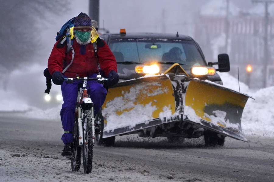 A bicyclist peddles on slick roads during a winter snow storm, Tuesday, Feb. 2, 2021, in Brunswick, Maine. (AP Photo/Robert F.