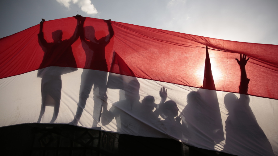 FILE - In this Sept. 26, 2016, file photo, men are silhouetted against a large representation of the Yemeni flag as they attend a ceremony to mark the anniversary of North Yemen&#039;s Sept. 26, 1962 revolution in Sanaa, Yemen. President Joe Biden&#039;s announcement that the U.S. will end its support of a Saudi-led coalition&#039;s years-long war against Yemen&#039;s Houthi rebels likely will increase pressure on the kingdom to end its campaign there, though reaching an enduring peace for the Arab world&#039;s poorest country still remains in question.