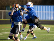 Ridgefield senior Tanner Roberts tries to swat away a pass attempt during a practice on Wednesday, March 3, 2021, at Ridgefield High School. Playing his fifth position in three years, Roberts continues to show his instincts and leadership are key to his football success.