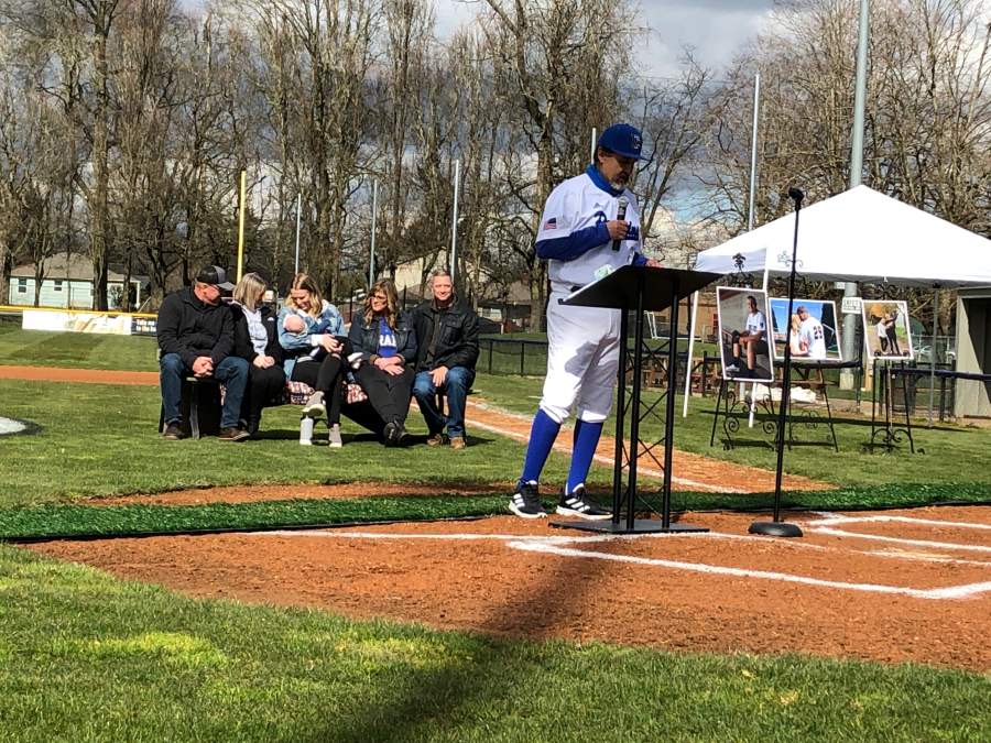 Clark College baseball coach Mark Magdaleno speaks in honor of former pitcher Grant Fisher on Saturday at Walker Stadium in Portland. Behind Magdaleno is Fisher&#039;s family, including wife Caitlin and daughter Ellagrace. Fisher was killed on Jan. 29 when his vehicle was hit by an allegedly impaired driver.
