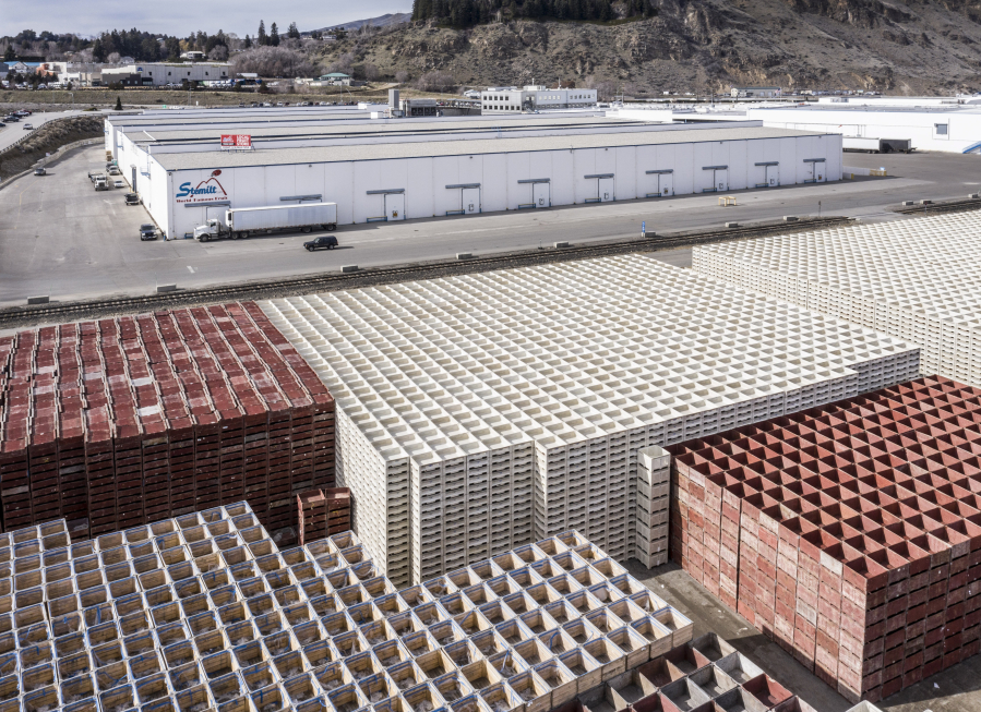 Empty fruit bins that would ordinarily be filled and exported overseas in cargo containers are waiting at Stemilt GrowersCf`U fruit-packing plant in Wenatchee, Washington on March 8, 2021.