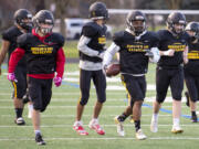 Dylan Damos, left, and Jamarion Hinton, right,  lead of a flock of Eagles as they run back to the huddle on Wednesday, March 10, 2021, at Hudson&#039;is Bay High School. The Eagles have formed a unique bond through their shared experiences, and coach Ray Lions has embraced and cultivated the family-like atmosphere.