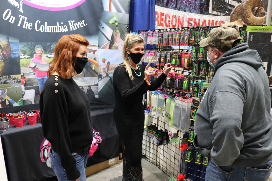 Exhibitors at the Central Oregon Sportsmen&#039;s Show in Redmond answer questions for a guest about fishing gear they are selling. The show was a first for the region after most such events were shut down by the COVID-19 pandemic, and a trial for the Portland show.