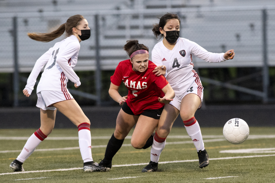 Camas sophomore Bella Burns fights through Union defenders Ashley Elcock, left, and Isabella Barrett in a 4A Greater St. Helens League girls soccer match on Friday, March 26, 2021, at Doc Harris Stadium. Camas won 2-0 to improve to 10-0 on the season.