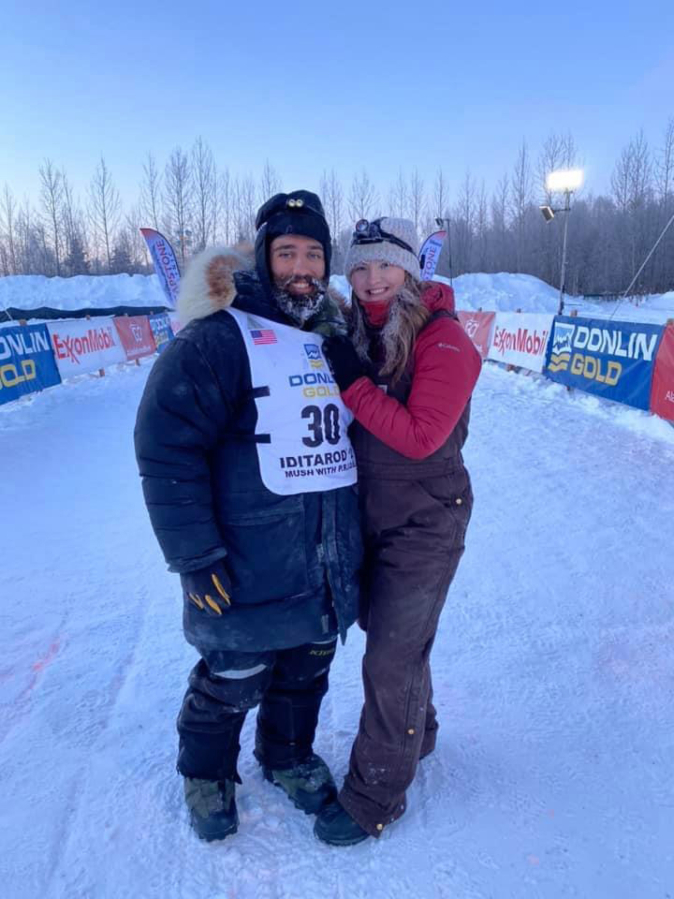 Josh McNeal poses with his wife Jobie after completing the 2021 Iditarod Sled Dog race.