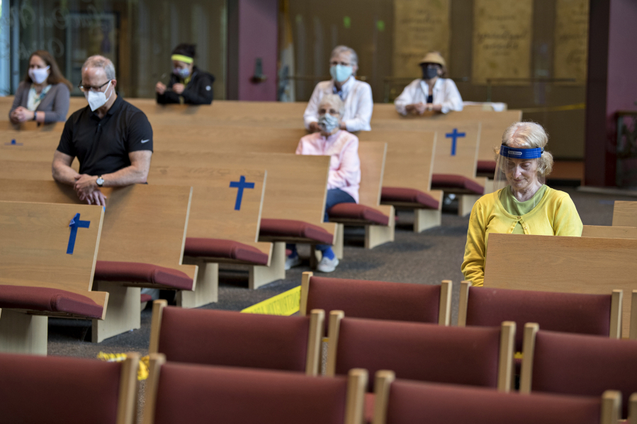 Connie Kessinger of St. Joseph Catholic Church, right, bows her head in prayer before the service on June 18, 2020. As churches slowly reopen, the traditional Catholic Mass has shifted to adapt to COVID-19.