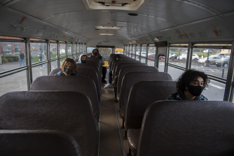 Senior Anthony Lozano, 17, right, joins fellow students on board the school bus as they wait to attend classes in person at Heritage High School on Thursday morning, March 4, 2021. Teachers and staff welcomed back students in all high school grades for the first time since March 13 when schools closed for coronavirus.