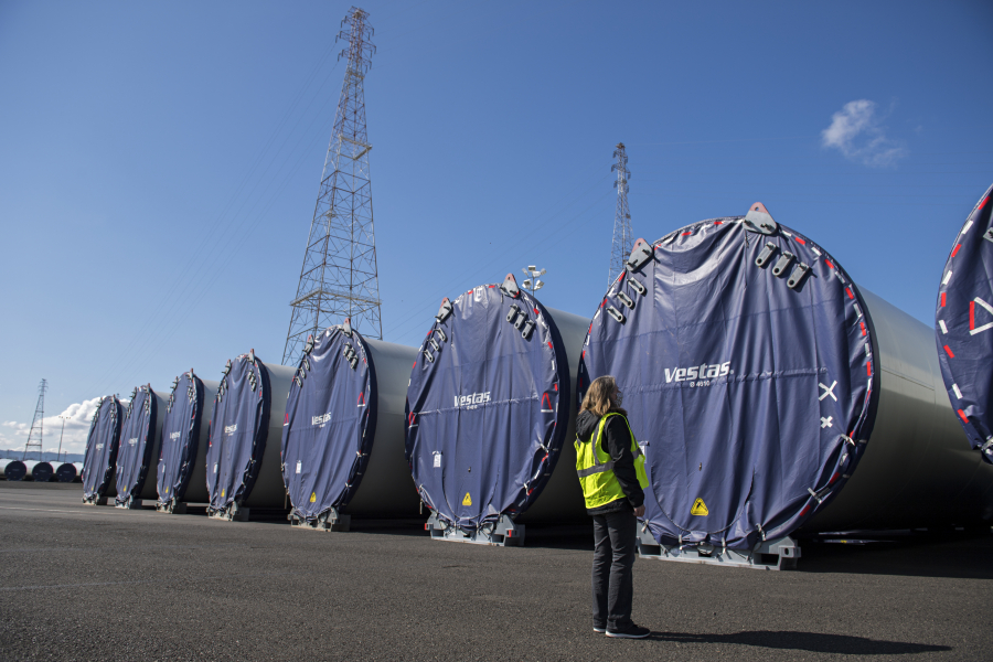 Katie Odem, marketing communications manager for the Port of Vancouver, looks over wind turbine towers that are currently being stored at the port and are waiting to be shipped out by truck. A record-breaking year of wind component imports helped the port during an otherwise challenging 2020 due to the COVID-19 pandemic.