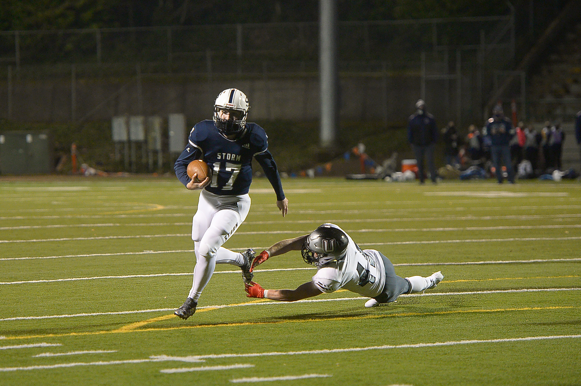 Skyview quarterback Clark Coleman evades a tackle by Union's Jaden Hornsby en route to scoring a touchdown at Kiggins Bowl on Friday night, March 12, 2021.