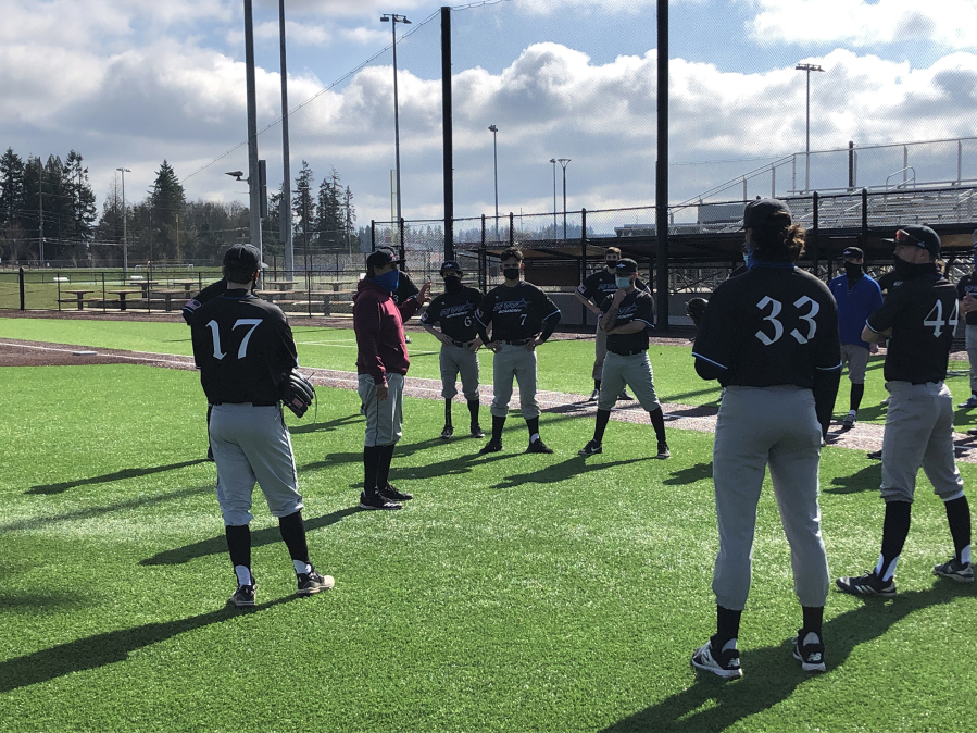 Clark College baseball coach Mark Magdaleno, in red, talks with his team at a practice Wednesday at Ridgefield Outdoor Recreation Complex. Clark&#039;s players are playing as the independent club team NW Star after the college canceled spring sports two weeks ago.