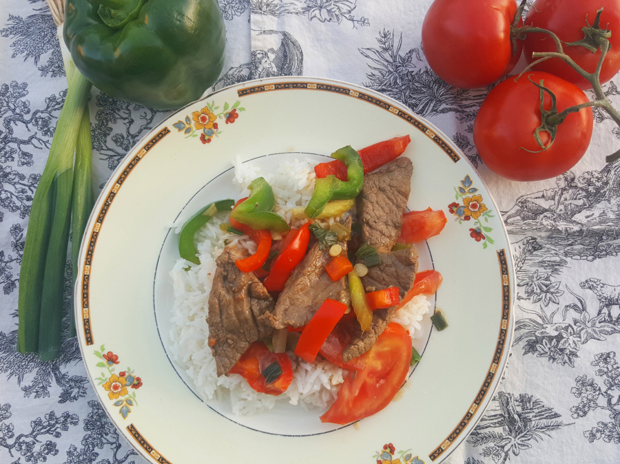 With strips of juicy steak, bell peppers, scallions and tomatoes, this stir-fried meal makes a very colorful plate.