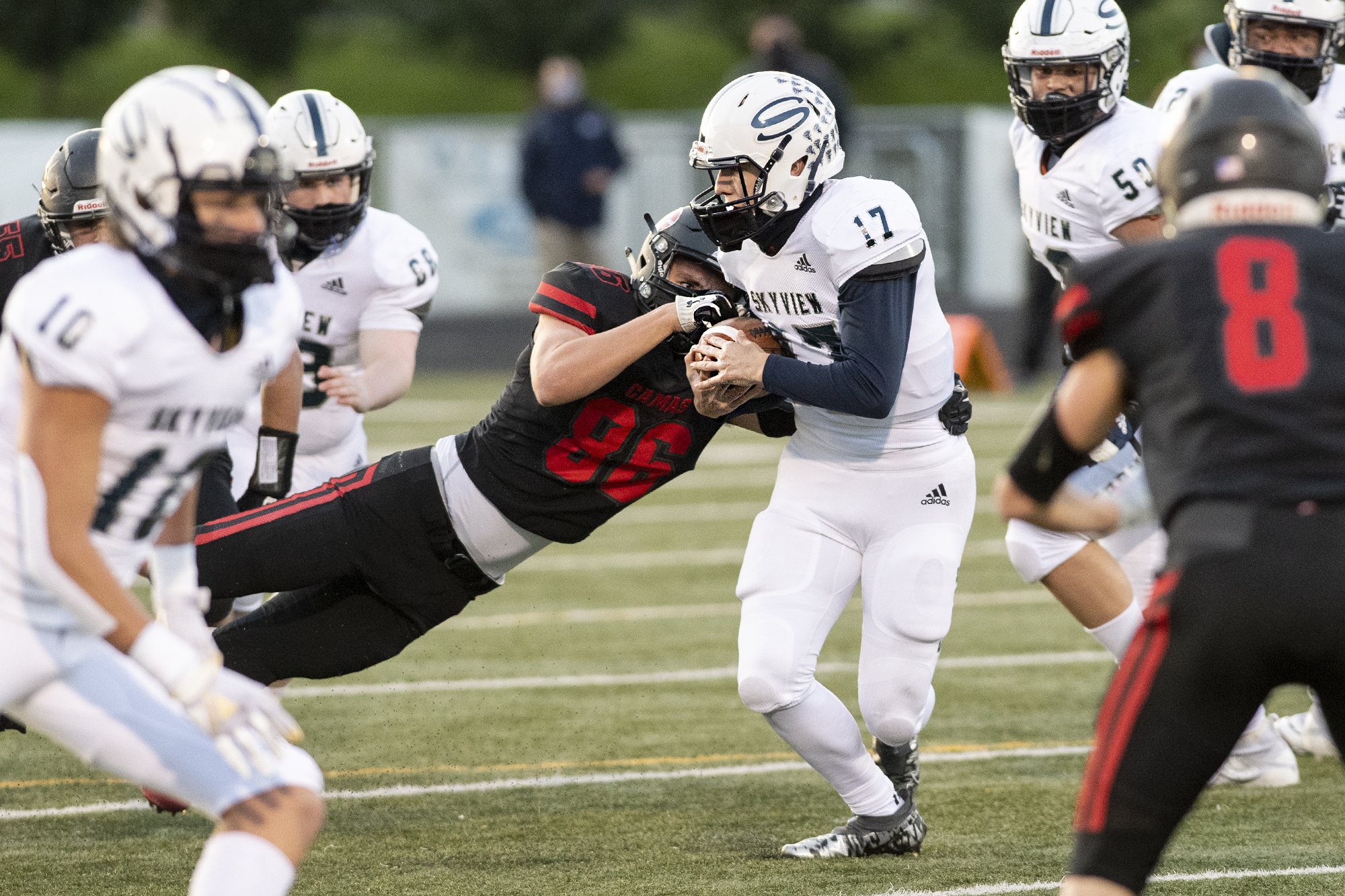 Camas’ Holt Williams punches the ball out of Skyview quarterback Clark Coleman’s grasp in a 4A Greater St. Helens League football game on Tuesday, March 23, 2021, at Doc Harris Stadium.