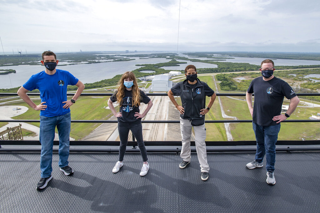 In this photo provided by SpaceX, Jared Isaacman, from left to right, Hayley Arceneaux, Sian Proctor and Chris Sembroski pose for a photo, Monday, March 29, 2021, from the SpaceX launch tower at NASA’s Kennedy Space Center at Cape Canaveral, Fla.