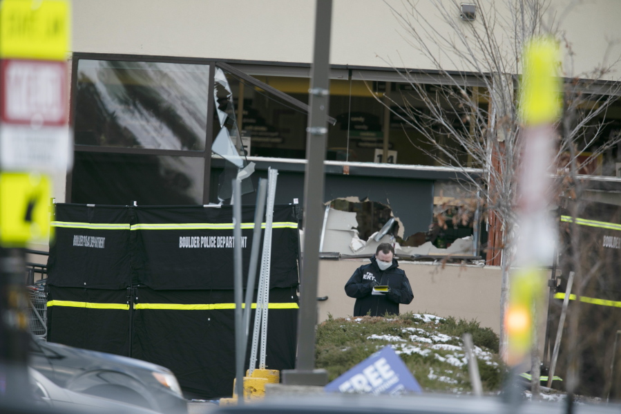 Police work on the scene outside of a King Soopers grocery store where authorities say multiple people were killed in a shooting, Monday, March 22, 2021, in Boulder, Colo..