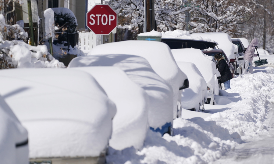 Snow covers vehicles March 15 parked along Second Avenue after a powerful late winter storm dumped more than 2 feet of snow in Denver. The storm shut down major roadways, canceled school and closed the state legislature.