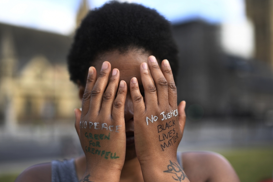FILE - In this file photo dated Sunday, June 21, 2020, a woman symbolically covers her eyes as she participates in a Black Lives Matter protest calling for an end to racial injustice, at the Parliament Square in central London.  A government inquiry, by a panel of experts, has concluded Wednesday March 31, 2021, that there is racism in Britain, but it&#039;s not a systematically racist country that is &quot;rigged&quot; against non-white people, though many ethnic-minority Britons greeted that claim with skepticism.