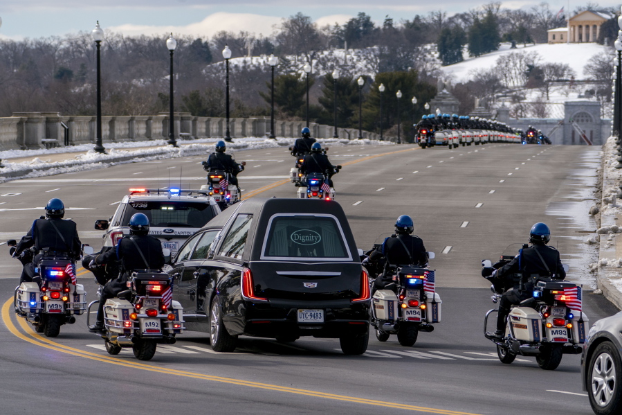 FILE - In this Feb. 3, 2021 file photo, a hearse carrying the remains of U.S. Capitol Police officer Brian Sicknick makes its way to Arlington National Cemetery after Sicknick was lying in honor at the U.S Capitol, Wednesday, Feb. 3, 2021, in Washington.