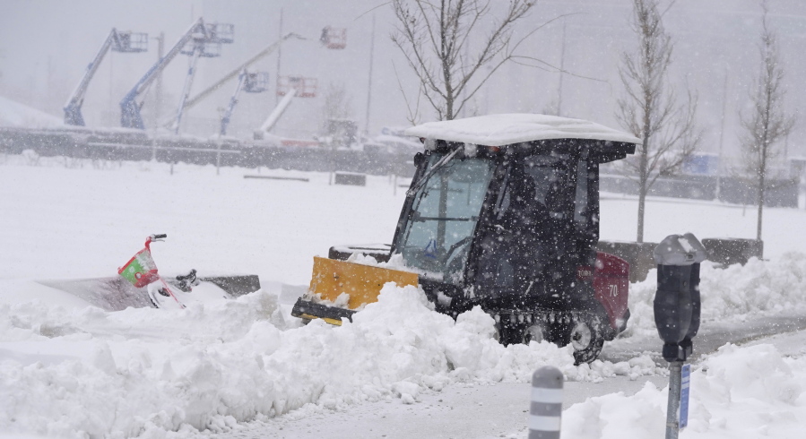 A maintenance worker uses a plow as a snowstorm rips across the intermountain West Sunday, March 14, 2021, in Denver. Forecasters are calling for the storm to leave at least another six inches of snow during the day before moving out on to the eastern plains.