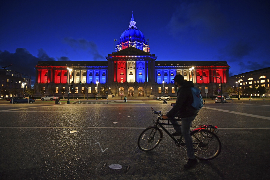 A bicyclist stops to admire the red, white and blue lights illuminating San Francisco City Hall in San Francisco, Calif., Friday, Nov. 6, 2020. Congress is beginning debate on the biggest overhaul of U.S. elections law in a generation. Legislation from Democrats would touch virtually every aspect of the electoral process -- striking down hurdles to voting, curbing partisan gerrymandering and curtailing big money in politics. Republicans see those very measures as a threat that would limit the power of states to conduct elections and ultimately benefit Democrats.