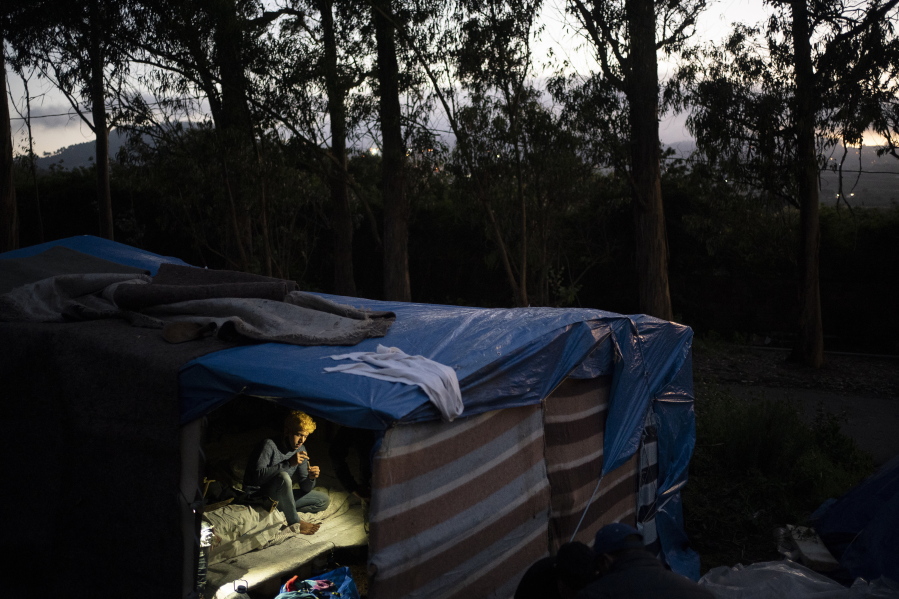 A migrant rests in Las Raices camp in San Cristobal de la Laguna, in the Canary Island of Tenerife, Spain, Wednesday, March 17, 2021. Several thousand migrants have arrived on the Spanish archipelago in the first months of 2021. Due to the terrible living conditions and the poor quality of food and water at the Las Raices camp, some migrants have decided to leave the camp and sleep in shacks in a nearby forest instead.