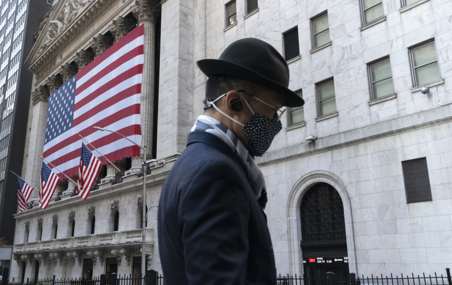 FILE - In this Nov. 16, 2020 file photo a man wearing a mask passes the New York Stock Exchange in New York. Stocks are moving modestly higher in early trading on Wall Street as investors cautiously welcome signs of calm in the bond market. The S&amp;P 500 was up 0.4% early Thursday, March 4, 2021, and the yield on the 10-year Treasury held steady at 1.47%.