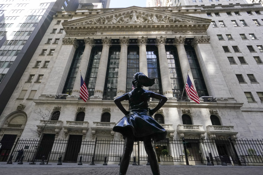 FILE - In this Tuesday, March 23, 2021 file photo, the Fearless Girl statue stands in front of the New York Stock Exchange in New York&#039;s Financial District. On Monday, March 29, 2021, stocks are off to a mixed start on Wall Street as losses for banks are offset by gains in several Big Tech companies.
