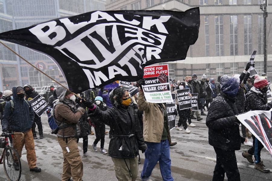 A group of protesters march in the snow around the Hennepin County Government Center, Monday, March 15, 2021, in Minneapolis where the second week of jury selection continues in the trial for former Minneapolis police officer Derek Chauvin. Chauvin is charged with murder in the death of George Floyd during an arrest last may in Minneapolis.