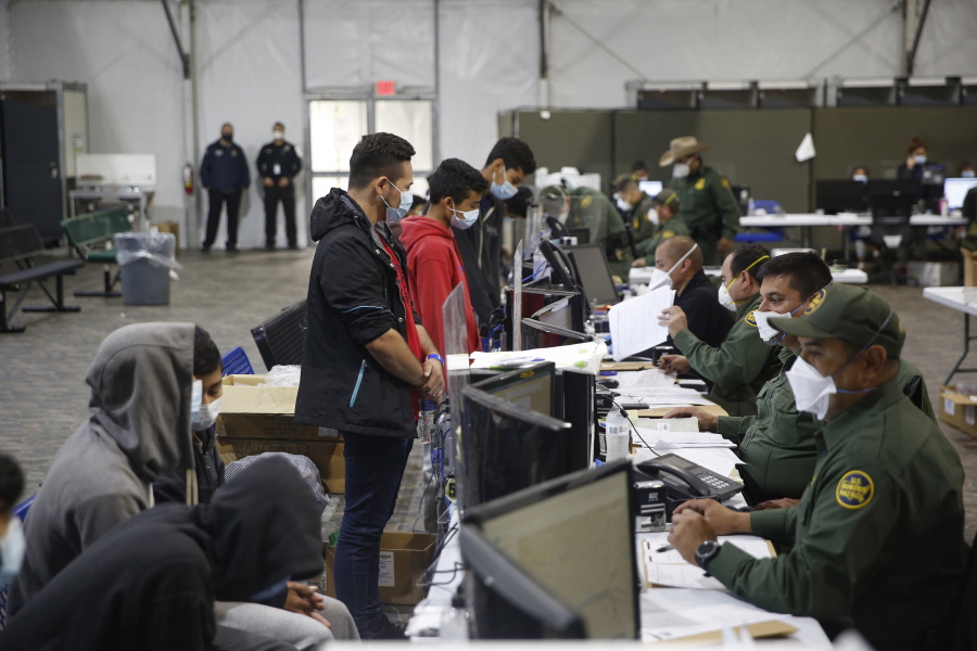 Migrants are processed at the intake area of the Donna Department of Homeland Security holding facility, the main detention center for unaccompanied children in the Rio Grande Valley, in Donna, Texas, Tuesday, March 30, 2021.