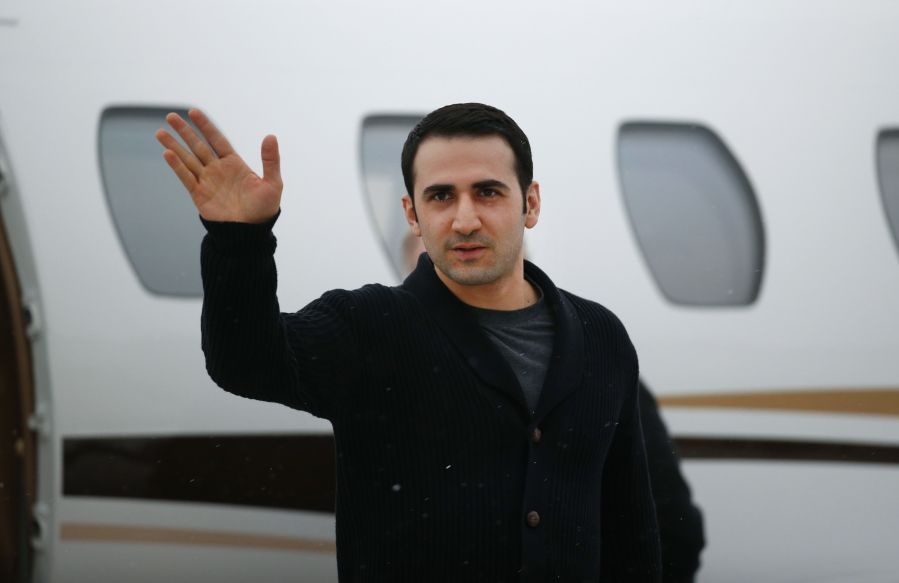 FILE - In this Jan. 21, 2016, file photo, Amir Hekmati waves after arriving on a private flight at Bishop International Airport in Flint, Mich. A former U.S. Marine freed from Iranian custody five years ago is in court with the American government over whether he can collect a multimillion-dollar payment from a special fund for victims of international terrorism. Newly filed court documents show that the FBI opened an investigation into Hekmati, on suspicions that he went to Iran to sell classified information to the regime. He vigorously disputes those allegations.